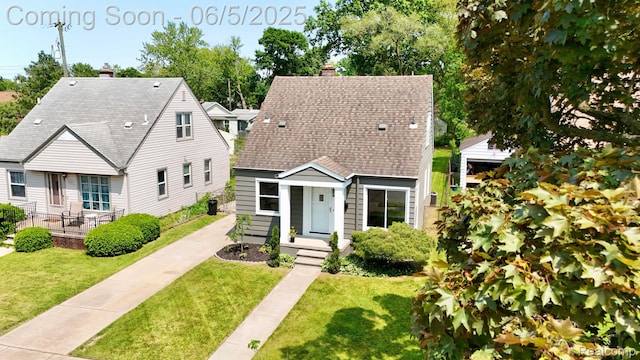 2231 Parker St, Dearborn, MI 48124 - view of front of house with a chimney, a front lawn, and a shingled roof