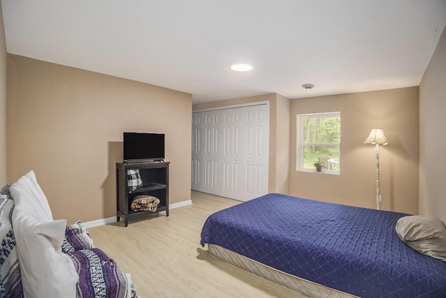 2635 E River Rd, Twin Lake, MI 49457 - bedroom with light wood-style flooring, a closet, and baseboards