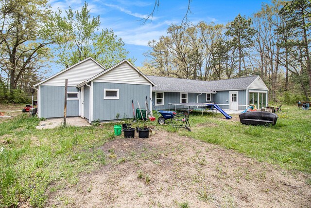 2635 E River Rd, Twin Lake, MI 49457 - rear view of house featuring a shingled roof and a lawn