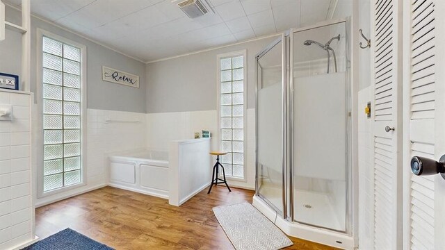 14883 Hideaway Dr, Vandalia, MI 49095 - full bath featuring a stall shower, crown molding, wood finished floors, and a bath
