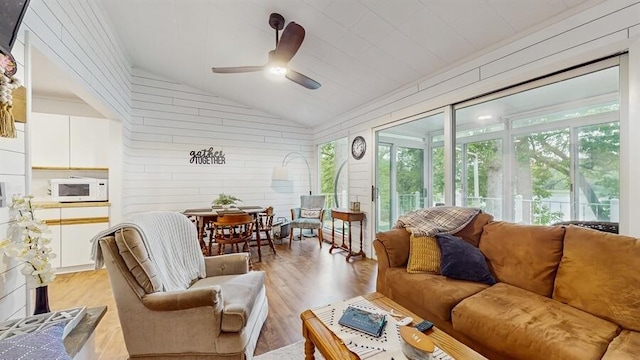 14883 Hideaway Dr, Vandalia, MI 49095 - living area featuring lofted ceiling, light wood finished floors, a ceiling fan, and wooden walls