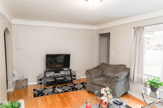 19176 Barlow St, Detroit, MI 48205 - living room with arched walkways, healthy amount of natural light, wood finished floors, and baseboards