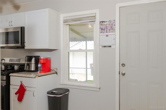 19176 Barlow St, Detroit, MI 48205 - kitchen with appliances with stainless steel finishes, white cabinetry, and light countertops