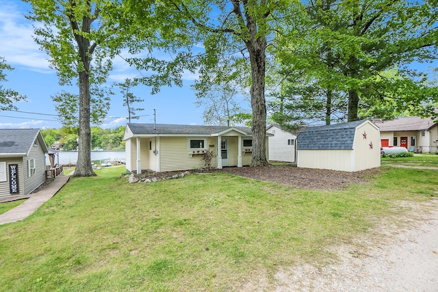 6026 Keeney Rd, Six Lakes, MI 48886 - view of front of property with a storage unit, a front lawn, and a water view