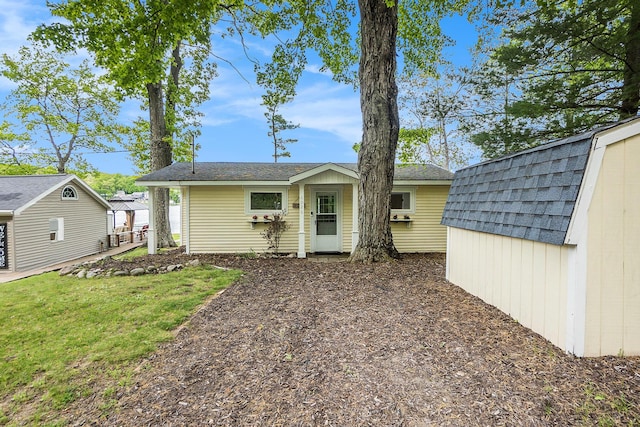 6026 Keeney Rd, Six Lakes, MI 48886 - back of property featuring an outbuilding, roof with shingles, and a yard