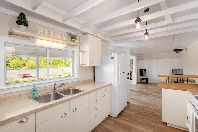 6026 Keeney Rd, Six Lakes, MI 48886 - kitchen with freestanding refrigerator, light wood-style flooring, range, light countertops, and beamed ceiling