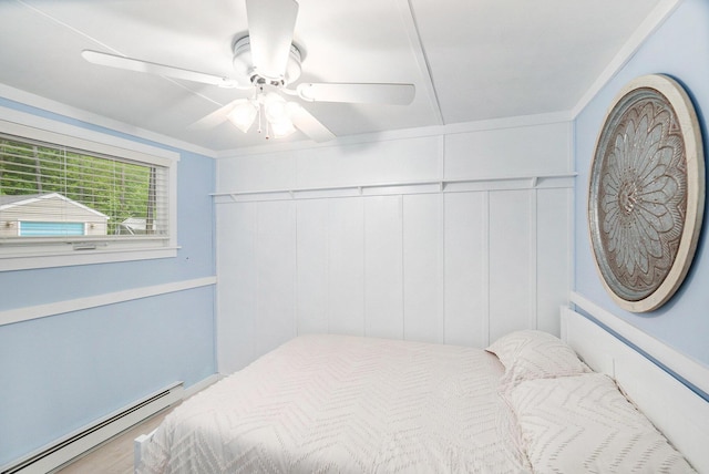 6026 Keeney Rd, Six Lakes, MI 48886 - bedroom with a baseboard radiator, a ceiling fan, wood finished floors, and a decorative wall