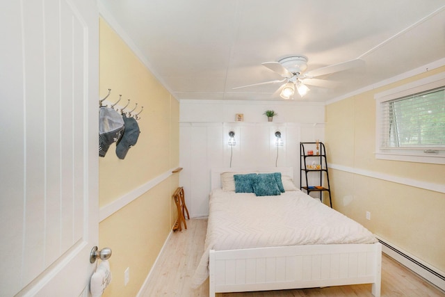 6026 Keeney Rd, Six Lakes, MI 48886 - bedroom featuring a baseboard radiator, wood finished floors, a ceiling fan, and ornamental molding