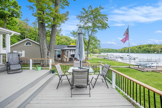 6026 Keeney Rd, Six Lakes, MI 48886 - wooden terrace with outdoor dining area, a lawn, and a water view