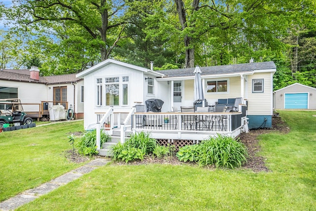 6026 Keeney Rd, Six Lakes, MI 48886 - back of house with a yard, a garage, a wooden deck, and an outbuilding