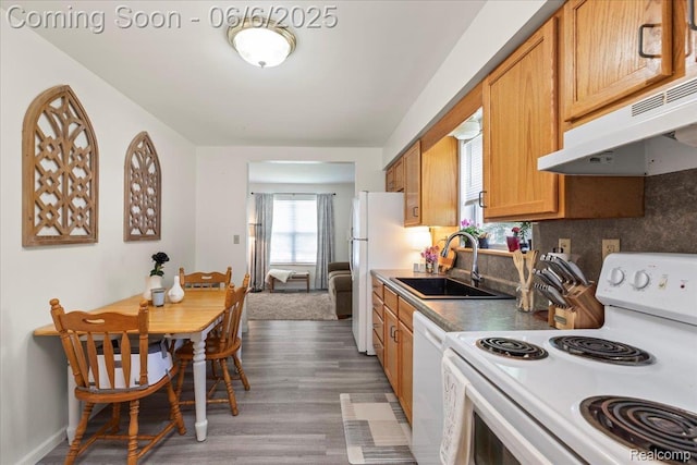 501 Front St, Holly, MI 48442 - kitchen with white appliances, a sink, under cabinet range hood, wood finished floors, and brown cabinetry