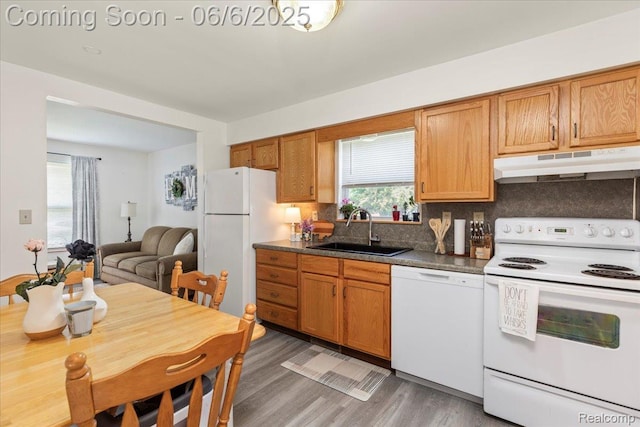 501 Front St, Holly, MI 48442 - kitchen with white appliances, under cabinet range hood, a sink, backsplash, and light wood finished floors