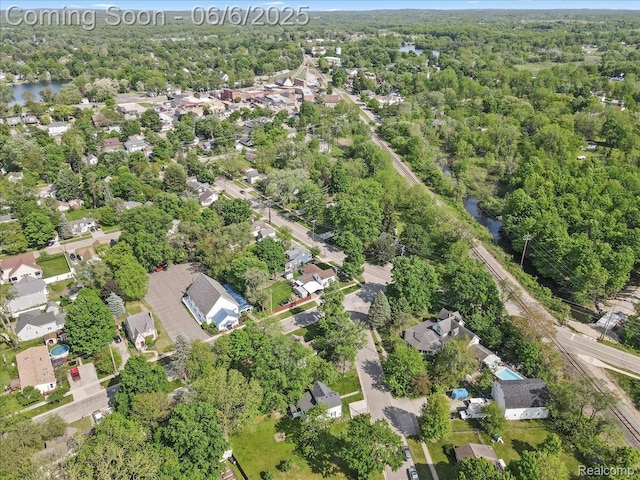 501 Front St, Holly, MI 48442 - aerial overview of property's location featuring nearby suburban area, a nearby body of water, and a heavily wooded area