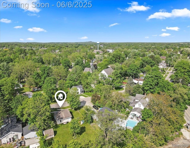 501 Front St, Holly, MI 48442 - aerial view of property and surrounding area featuring a heavily wooded area