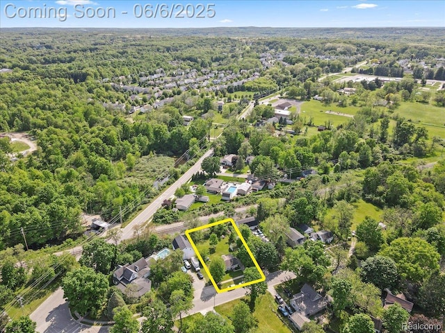 501 Front St, Holly, MI 48442 - aerial view of property and surrounding area with a forest and property parcel outlined