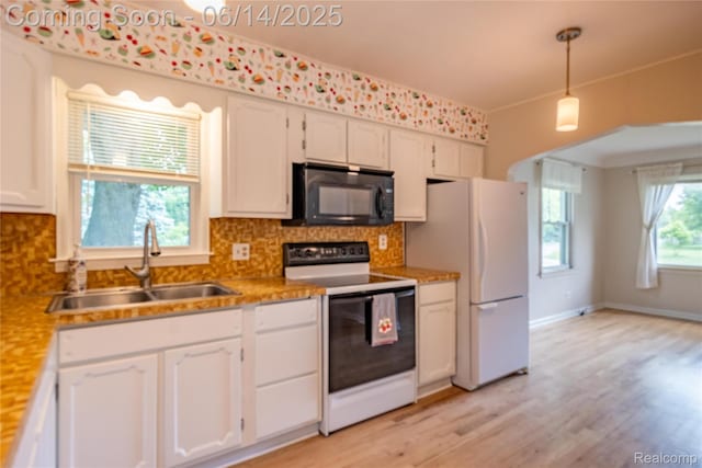 2375 Nichols Ave, Grand Blanc, MI 48507 - kitchen with black microwave, range with electric cooktop, white cabinets, and freestanding refrigerator