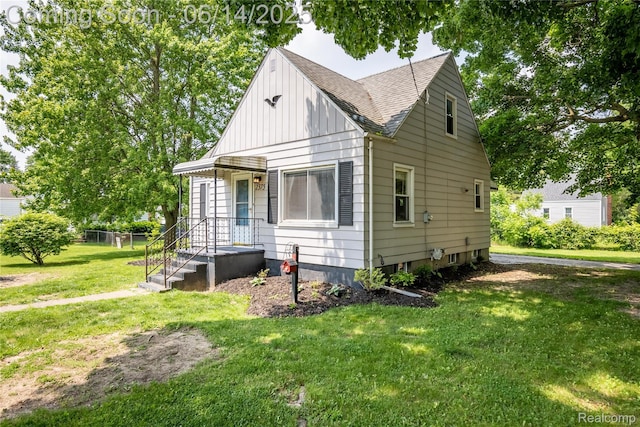 2375 Nichols Ave, Grand Blanc, MI 48507 - view of front of home with a front yard, roof with shingles, and board and batten siding