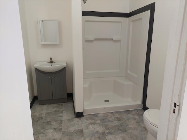 27 Rose St SW, Grand Rapids, MI 49507 - bathroom featuring a shower stall, vanity, and toilet