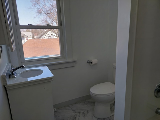 27 Rose St SW, Grand Rapids, MI 49507 - bathroom with marble look tiles, toilet, vanity, and baseboards