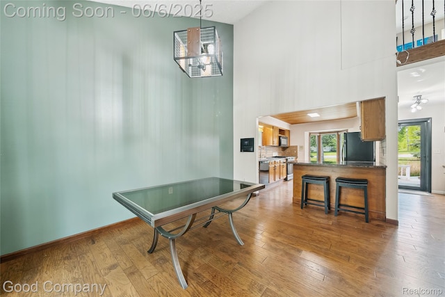5490 Clarkston Rd, Clarkston, MI 48348 - recreation room with a towering ceiling, hardwood / wood-style flooring, and baseboards