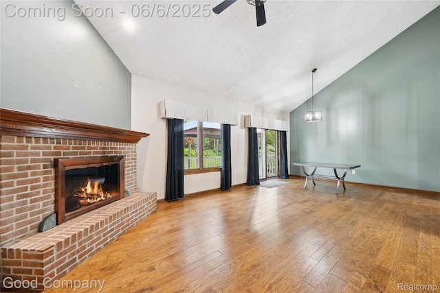 5490 Clarkston Rd, Clarkston, MI 48348 - unfurnished living room with a fireplace, a textured ceiling, high vaulted ceiling, ceiling fan, and hardwood / wood-style floors