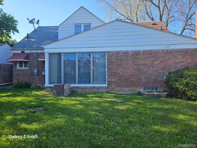 18941 Puritan St, Detroit, MI 48223 - back of house featuring brick siding, a lawn, and central air condition unit