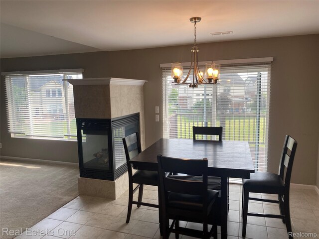 29337 Woodpark Cir Unit 60, Warren, MI 48092 - dining room featuring a fireplace, a chandelier, light tile patterned floors, and light carpet