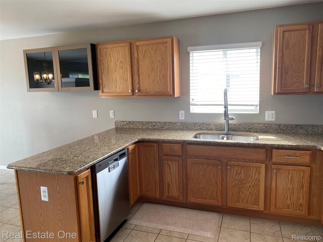 29337 Woodpark Cir Unit 60, Warren, MI 48092 - kitchen with stainless steel dishwasher, brown cabinets, light tile patterned floors, dark stone counters, and a peninsula