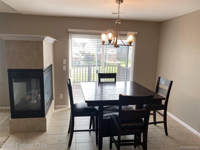 29337 Woodpark Cir Unit 60, Warren, MI 48092 - dining room featuring a multi sided fireplace, a chandelier, and light tile patterned flooring