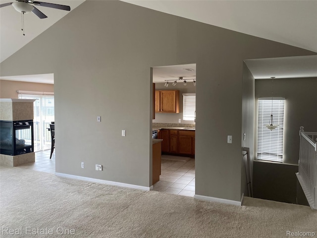29337 Woodpark Cir Unit 60, Warren, MI 48092 - unfurnished living room featuring light carpet, a ceiling fan, high vaulted ceiling, rail lighting, and light tile patterned flooring
