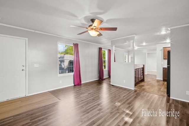 2575 Theodore Ave, Hudsonville, MI 49426 - unfurnished living room featuring ceiling fan, ornamental molding, dark wood finished floors, and baseboards