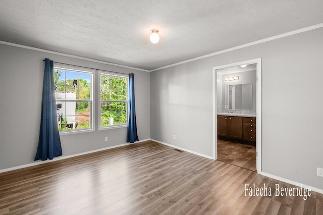 2575 Theodore Ave, Hudsonville, MI 49426 - empty room featuring wood finished floors, a textured ceiling, crown molding, and baseboards