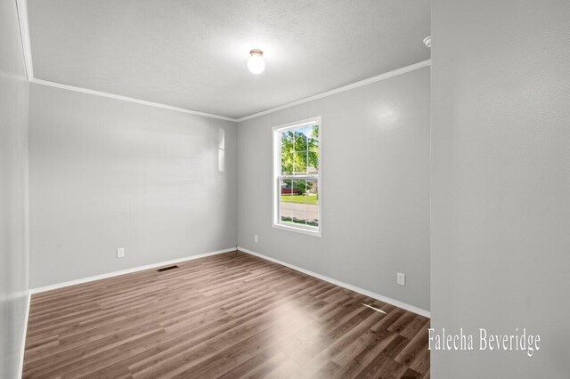 2575 Theodore Ave, Hudsonville, MI 49426 - empty room featuring crown molding, wood finished floors, a textured ceiling, and baseboards