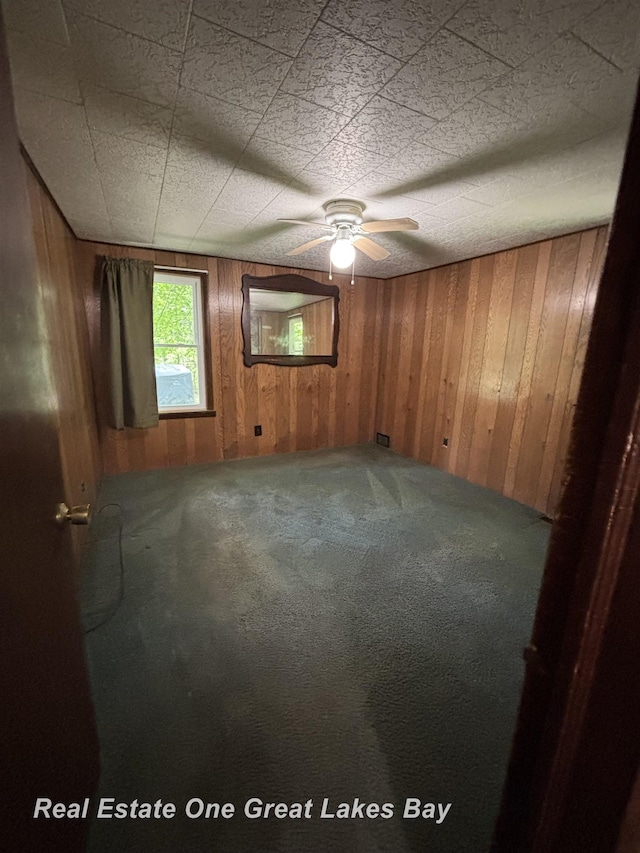 8446 Bamfield Rd, South Branch, MI 48761 - carpeted spare room featuring wooden walls and ceiling fan
