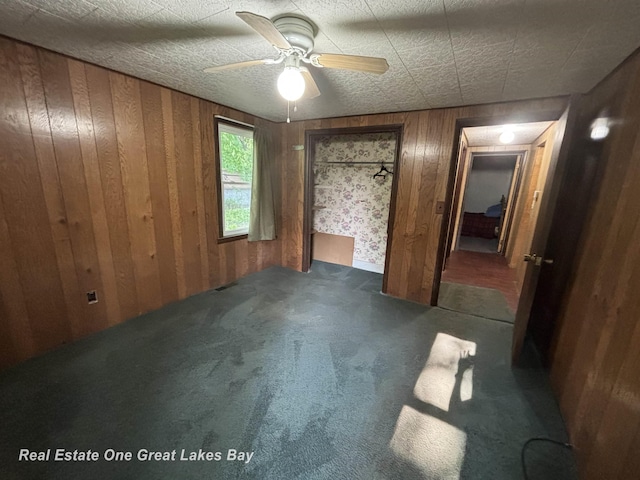 8446 Bamfield Rd, South Branch, MI 48761 - unfurnished bedroom featuring wooden walls, carpet flooring, and ceiling fan
