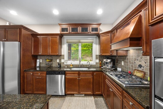 1708 N Norris Rd, Middleville, MI 49333 - kitchen with stainless steel appliances, a sink, custom range hood, backsplash, and dark stone counters