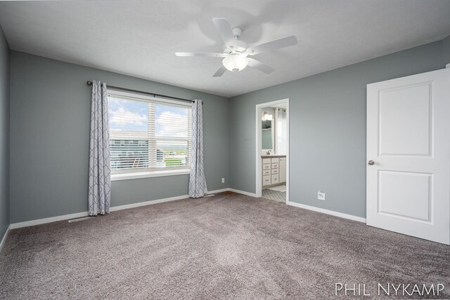 3880 Elm Ridge Dr, Holland, MI 49424 - unfurnished bedroom with carpet floors, baseboards, ensuite bathroom, and ceiling fan