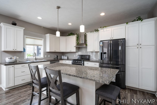 3880 Elm Ridge Dr, Holland, MI 49424 - kitchen featuring stainless steel appliances, wall chimney exhaust hood, a sink, decorative backsplash, and dark wood finished floors