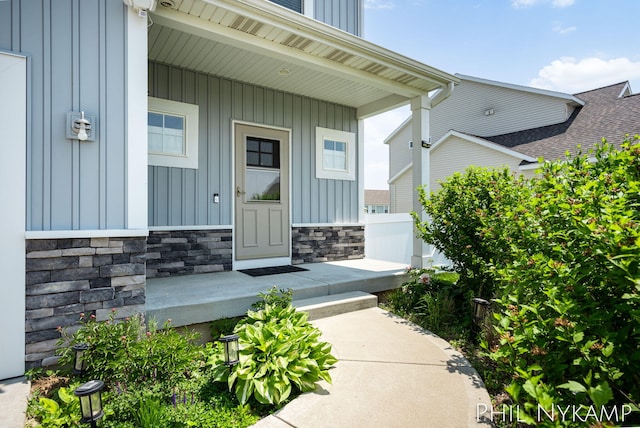 3880 Elm Ridge Dr, Holland, MI 49424 - property entrance with board and batten siding, covered porch, and stone siding
