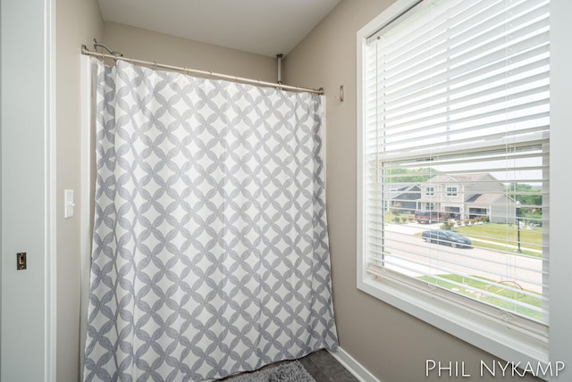 3880 Elm Ridge Dr, Holland, MI 49424 - bathroom view of a shower with curtain and baseboards