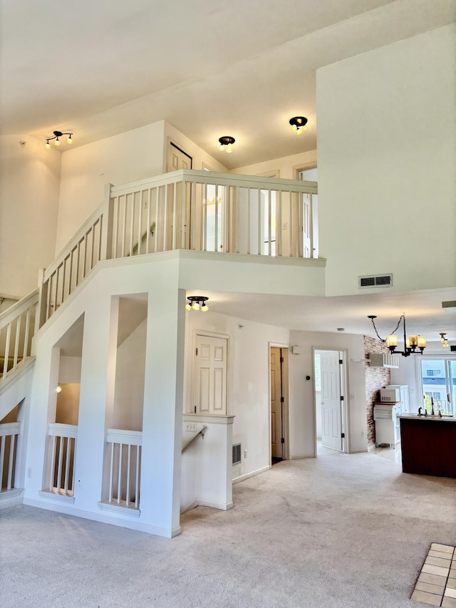 1870 Lindsay Ln, Ann Arbor, MI 48104 - unfurnished living room featuring a towering ceiling, carpet flooring, stairs, and a chandelier