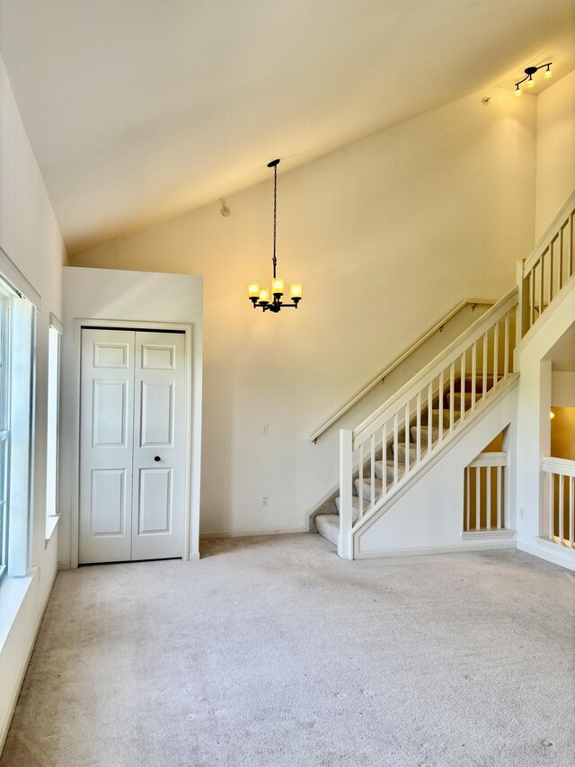 1870 Lindsay Ln, Ann Arbor, MI 48104 - spare room with carpet floors, a chandelier, stairs, and high vaulted ceiling