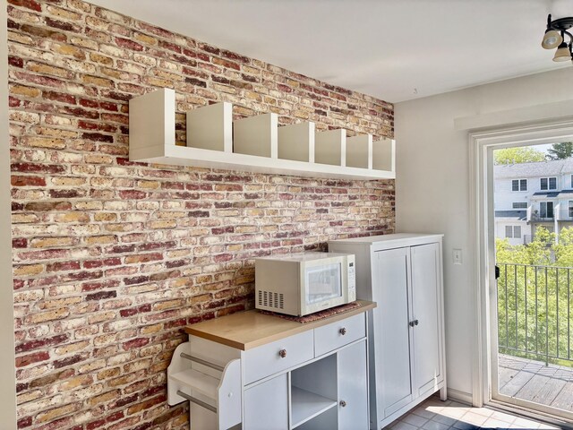 1870 Lindsay Ln, Ann Arbor, MI 48104 - kitchen with white microwave, open shelves, light tile patterned flooring, and white cabinetry