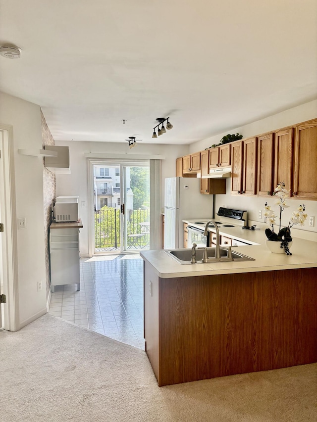 1870 Lindsay Ln, Ann Arbor, MI 48104 - kitchen with light carpet, brown cabinetry, a peninsula, a sink, and white appliances