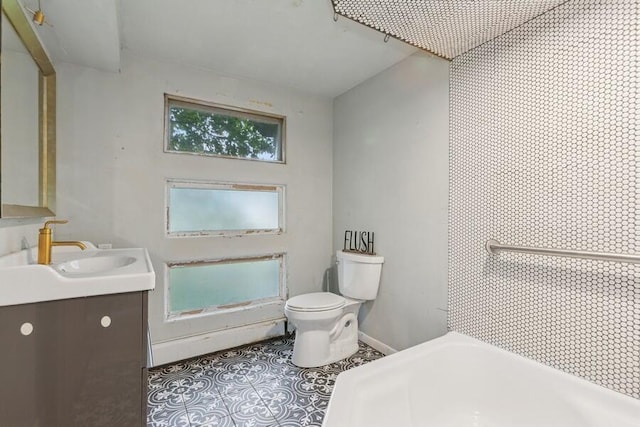 457 Gary Ave, Benton Harbor, MI 49022 - full bathroom featuring a tub to relax in, toilet, vanity, tile patterned flooring, and baseboards