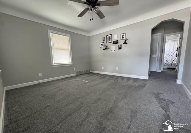 17765 Ruth St, Melvindale, MI 48122 - empty room with ceiling fan, dark carpet, arched walkways, and baseboards