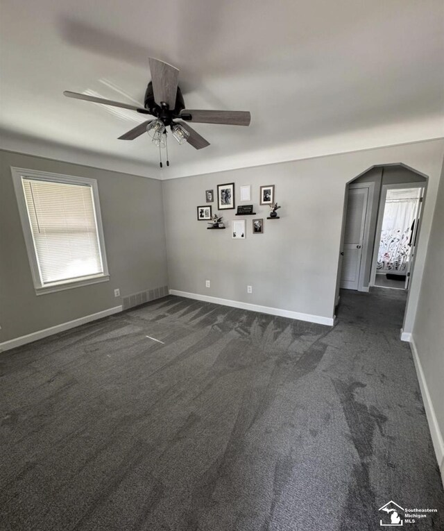 17765 Ruth St, Melvindale, MI 48122 - empty room featuring ceiling fan, dark colored carpet, and baseboards