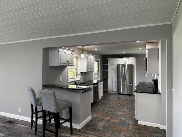 775 Riverview Dr, Plainwell, MI 49080 - kitchen featuring freestanding refrigerator, dark countertops, a peninsula, a sink, and crown molding