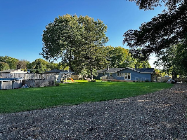 775 Riverview Dr, Plainwell, MI 49080 - view of yard with a covered pool, a playground, and a wooden deck