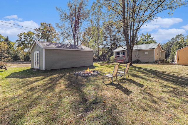 3459 N Morrie Ln, White Cloud, MI 49349 - view of grassy yard with an outdoor fire pit and an outbuilding